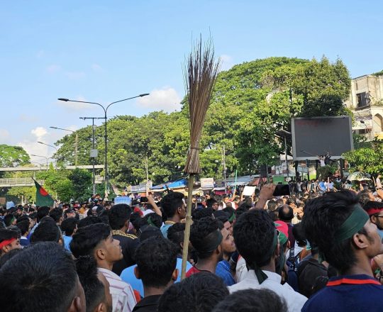 ঝাড়ু হাতে মিছিল করছেন একজন বিক্ষোভকারী।